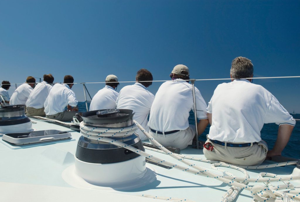 yacht crew sat on the deck in a line