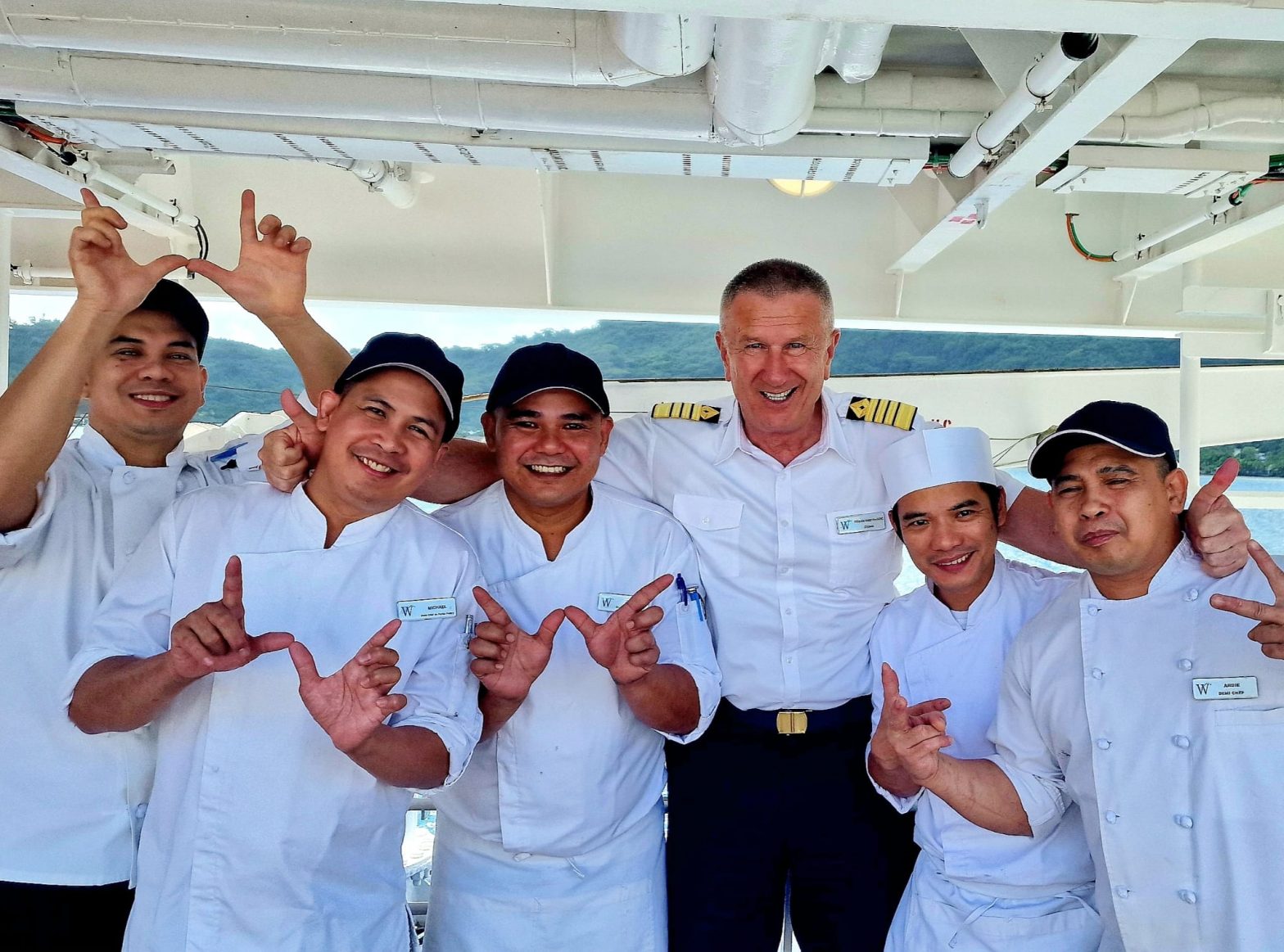 Image of Windstar Crew smiling at the camera, stood in a line